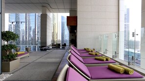 Un espace spa moderne doté de chaises longues, d ’une petite piscine et offrant une vue sur la ville.