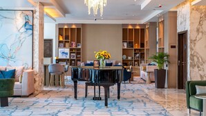 A lobby with a grand piano, a chandelier, and a marble floor. - voco Bonnington | Deluxe Room | Pool, Sauna + Steam, Dubai Marina Minutes (Dubai)