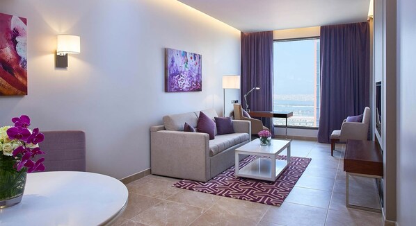 A modern living room with a sofa, coffee table, and a view of the city.