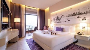 Una camera d'albergo moderna con un letto grande, una scrivania e un murale con vista sulla città.
