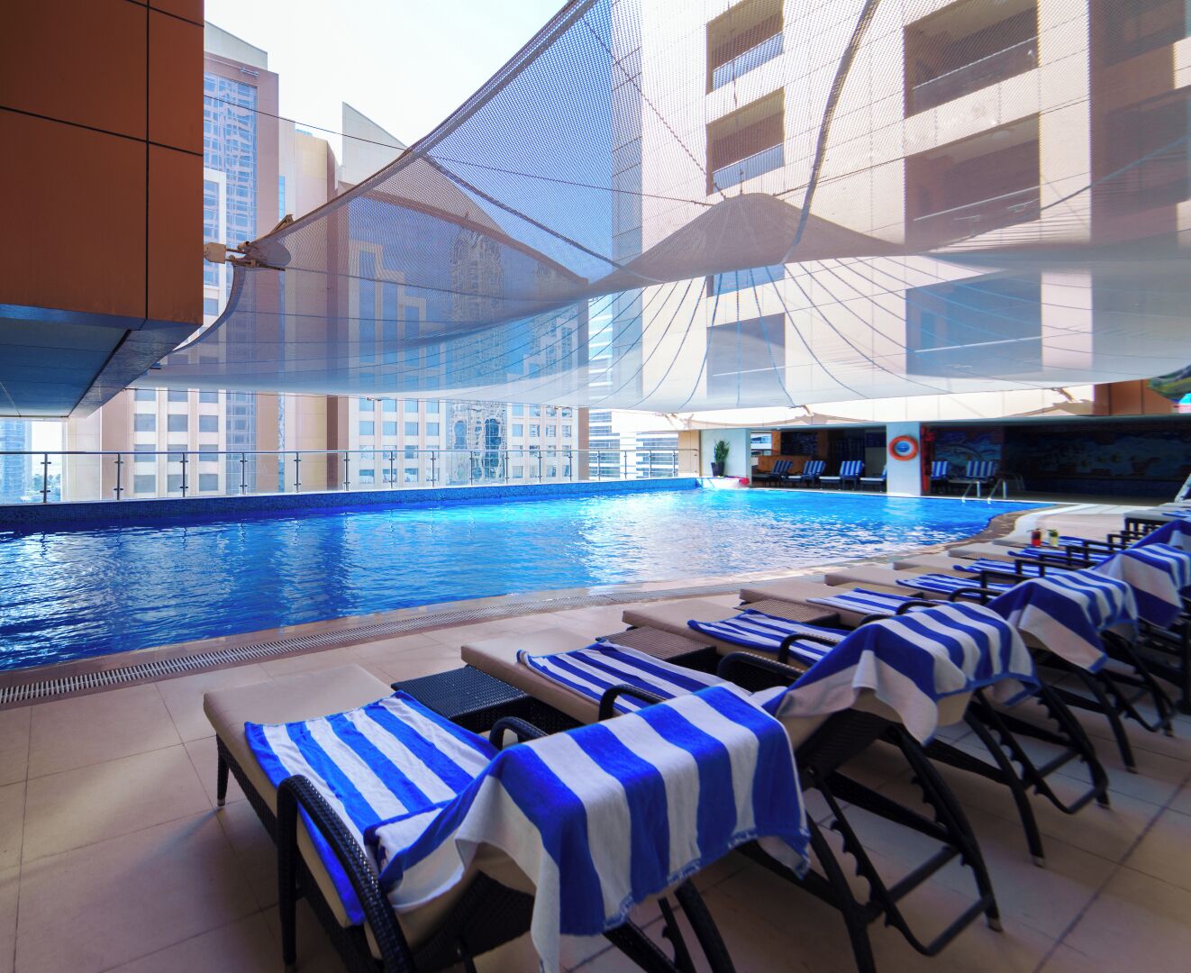 A poolside area with lounge chairs and a pool.