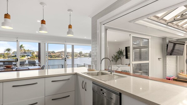 A modern kitchen with a large island, stainless steel appliances, and a view of a marina.