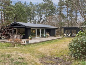 A modern house with a deck, large windows, and a garden. - 4 Star Holiday Home in Hojby (Hojby)