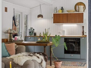 Ein gemütliches Wohnzimmer mit einer Couch, einem Couchtisch, einer Lampe und einer Topfpflanze.