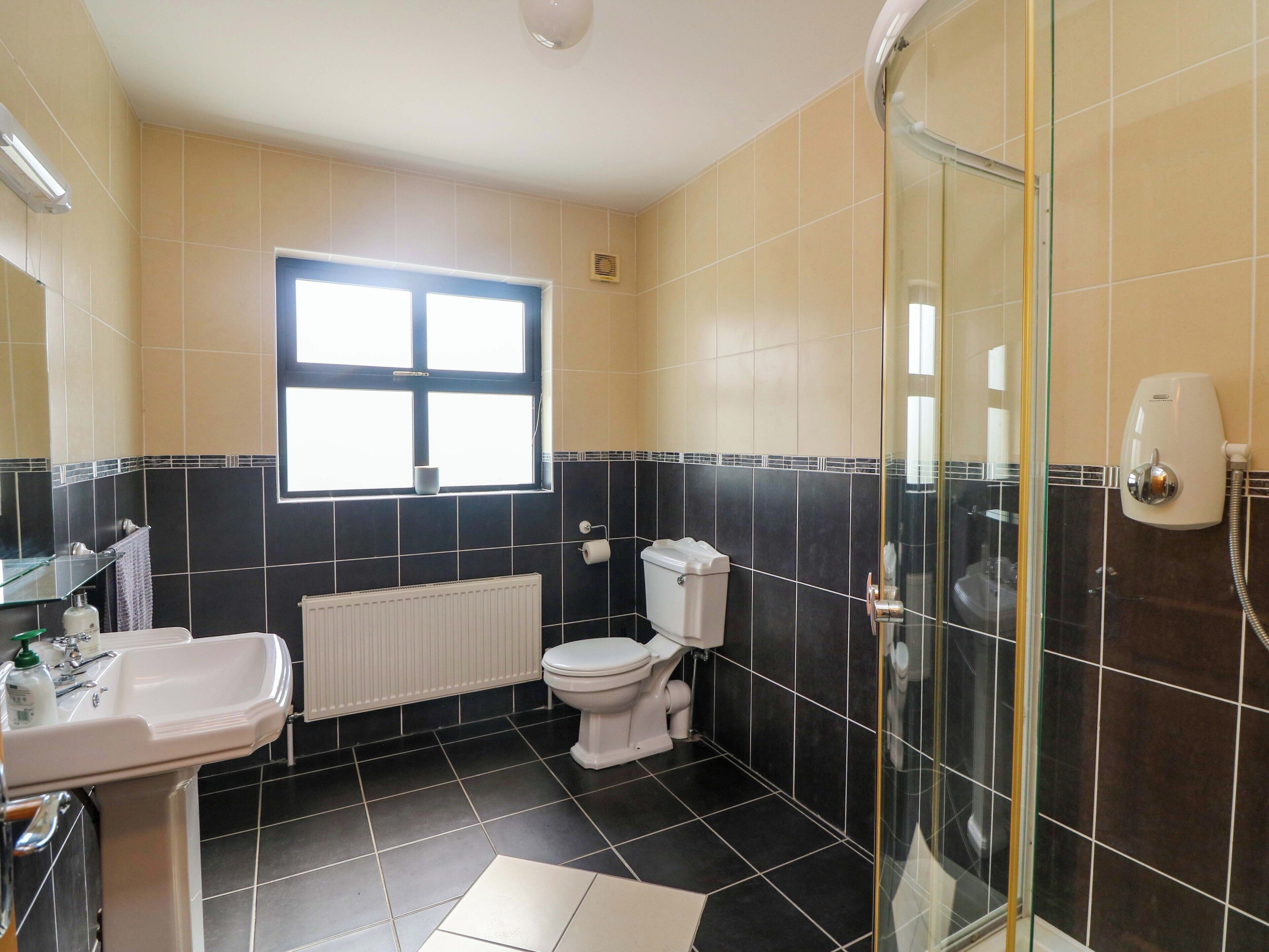 A bathroom with a toilet, sink, and shower.