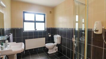 A bathroom with a toilet, sink, and shower.