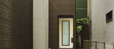 A modern building with a flat roof, a visible entrance, and a signboard with text.