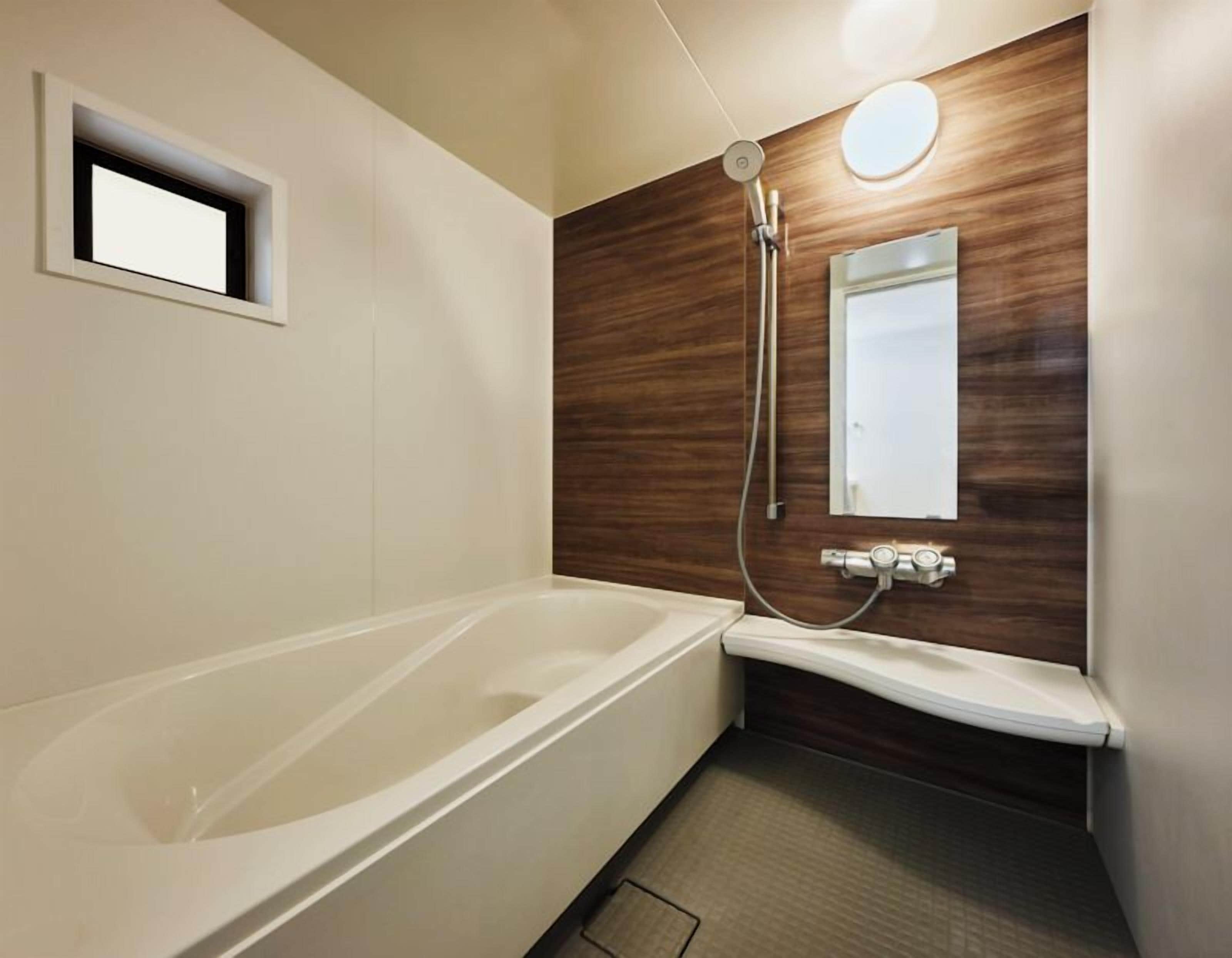 A modern bathroom with a bathtub, a shower, and a vanity.