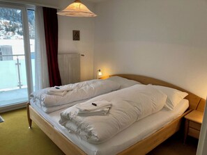 Ein Hotelzimmer mit Bett, Fenster, Heizkörper und Nachttisch.