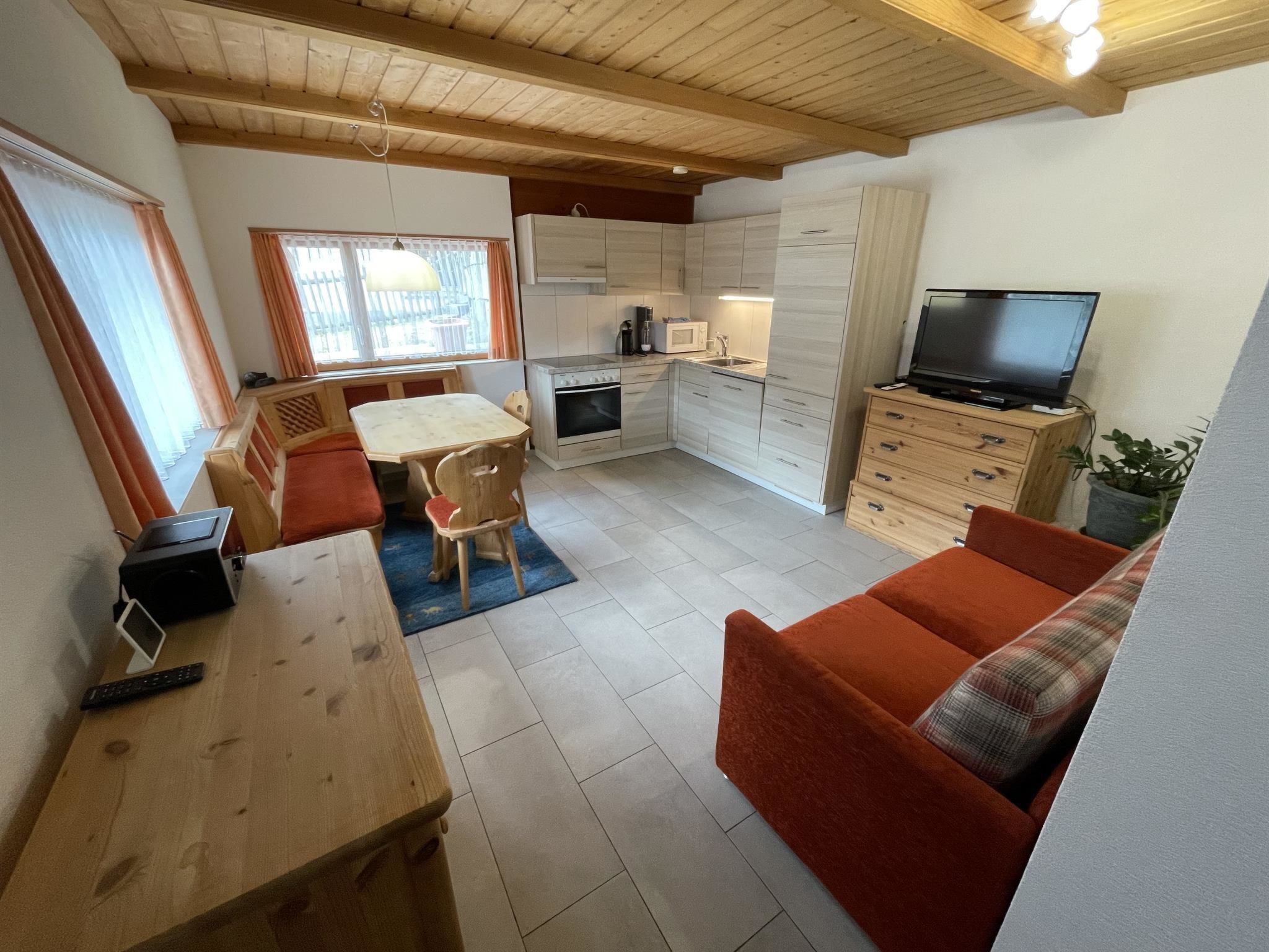 A compact living space with a dining area, kitchenette, and seating area.