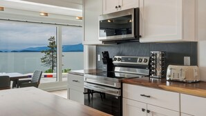Una cocina moderna con un ventanal grande, electrodomésticos de acero inoxidable y vistas a las montañas.