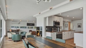 Una cocina moderna con armarios blancos, una mesa de comedor de madera y un horno empotrado.