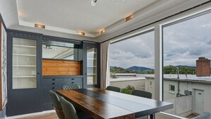 Una cocina moderna con un amplio comedor, armarios empotrados y vistas a la ciudad.