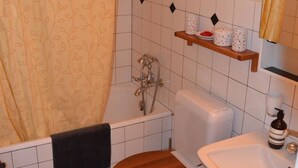 A bathroom with a bathtub, toilet, and sink. - Acla Sporz Davains Appartement/Fewo, Dusche, WC, Wohn-/Schlafraum by Interhome (Lenzerheide)