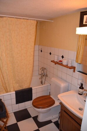 A bathroom with a bathtub, toilet, and sink. - Acla Sporz Davains Appartement/Fewo, Dusche, WC, Wohn-/Schlafraum by Interhome (Lenzerheide)