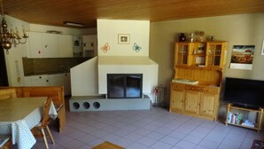 A cozy living room with a fireplace, wooden furniture, and a television. - Soleval Tavanera 118 Moritz Appartement/Fewo,   5-Bettwohnung (3 Zimmerwohnung) by Interhome (Lenzerheide)