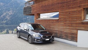 A car parked in front of a building with a wooden facade and a mountain view. - Clavo Vigl Appartement/Fewo Clavo Vigl by Interhome (Vaz)
