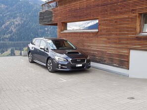 A car parked in front of a building with a wooden facade and a mountain view. - Clavo Vigl Appartement/Fewo Clavo Vigl by Interhome (Vaz)