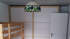 A room with a bunk bed, a chair, and a door. - Clavo Vigl Appartement/Fewo Clavo Vigl by Interhome (Vaz)