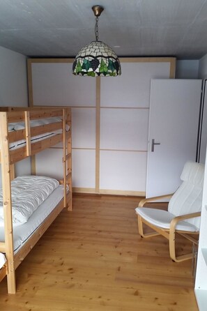 A room with a bunk bed, a chair, and a door. - Clavo Vigl Appartement/Fewo Clavo Vigl by Interhome (Vaz)