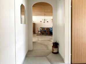 A hallway leading to a dining area with a wooden ceiling, a chandelier, and a table with chairs. - Haus Montana 3/3 Appartement/Fewo,   4-Bettwohnung by Interhome (Lenzerheide)