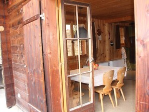 A wooden cabin interior with a dining table, chairs, and a kitchen area. - Freude am Berg Appartement/Fewo 8-Bettwohnung (4.5 Zimmer) by Interhome (MALIX)