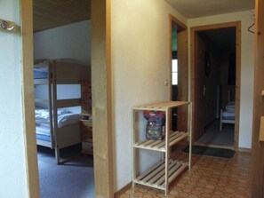 A room with bunk beds, a wooden shelf unit, and a tiled floor. - Freude am Berg Appartement/Fewo 8-Bettwohnung (4.5 Zimmer) by Interhome (MALIX)