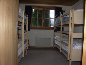 A room with bunk beds, a window, and a radiator. - Freude am Berg Appartement/Fewo 8-Bettwohnung (4.5 Zimmer) by Interhome (MALIX)