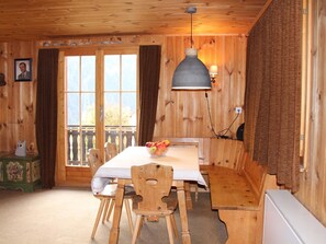 A wooden interior with a dining table, chairs, a hanging light fixture, and a window with curtains. - Freude am Berg Appartement/Fewo 8-Bettwohnung (4.5 Zimmer) by Interhome (MALIX)