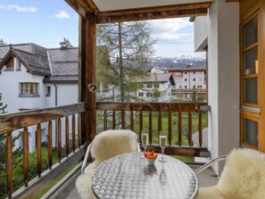 A balcony with a table and chairs, a glass of water, and a bowl of fruit. - Schweizerhof 424 Walker Appartement/Fewo,   2.5 Zimmerwohnung by Interhome (Lenzerheide)