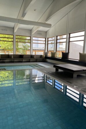 A swimming pool with a tiled floor and benches along the edge. - Schweizerhof 424 Walker Appartement/Fewo,   2.5 Zimmerwohnung by Interhome (Lenzerheide)