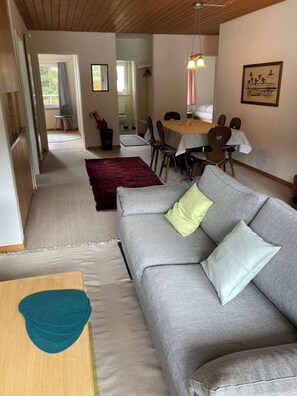 A living room with a grey sofa, a red rug, and a dining area with a table and chairs. - Haus Montana 1/6 Appartement/Fewo,   5-Bettwohnung by Interhome (Lenzerheide)