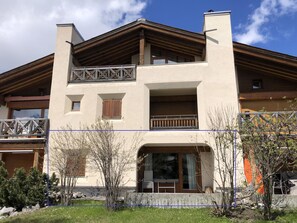 A two-story building with a balcony, large windows, and a stone facade. - Auf den Böden Haus B Appartement/Fewo,   Auf den Böden Haus B by Interhome (Parpan)