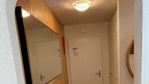 A narrow hallway with a wooden bench, a mirror, and a door with a sign. - Haus Montana 3/4 Appartement/Fewo,   7-Bettwohnung by Interhome (Lenzerheide)
