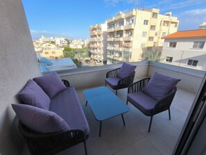 Un balcon avec un canapé, des chaises et une table.