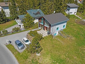 A modern two-story house with a sloped roof, a driveway, and two parked cars. - Golden Peaks Ferienhaus Ferienhaus, Dusche und Bad, WC, 4 oder mehr Schlafräume by Interhome (Valbella)