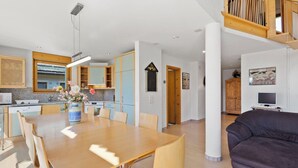 A modern interior with a dining area, kitchen, and living space. - Golden Peaks Ferienhaus Ferienhaus, Dusche und Bad, WC, 4 oder mehr Schlafräume by Interhome (Valbella)