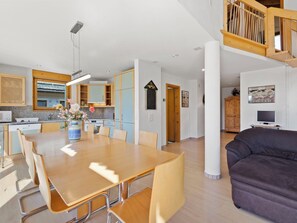Ein modernes Interieur mit Essbereich, Küche und Wohnbereich.