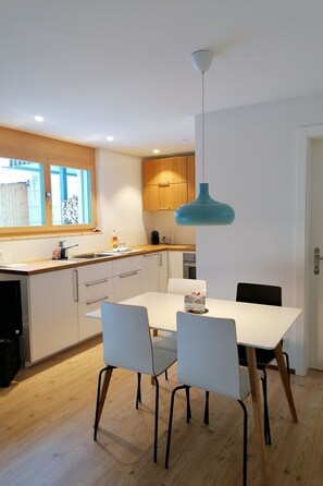A modern kitchen with a white countertop, wooden cabinets, and a blue pendant light. - CANOLS#32 Appartement/Fewo 4-Bettwohnung (2-Zimmerwohnung) by Interhome (Valbella)