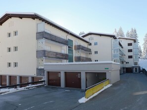 A multi-story building with balconies, a covered parking area, and a snow-covered environment. - Haus Montana 2/9 Appartement/Fewo,   4-Bettwohnung by Interhome (Lenzerheide)