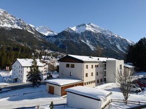 En snötäckt bergsstad med moderna byggnader och en fantastisk utsikt över bergen.