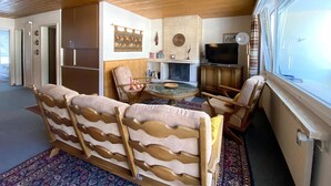 A living room with a sofa, chairs, a fireplace, a television, and a window. - Haus Montana 2/4 Appartement/Fewo,   4-Bettwohnung by Interhome (Lenzerheide)