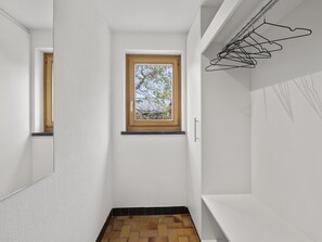 A narrow hallway with a small window, a wooden door, and a wall-mounted clothes rack. - Bellavista 6 Appartement/Fewo, Bad, WC, 3 Schlafräume Ferienwohnung Bellavista 6 by Interhome (Parpan)