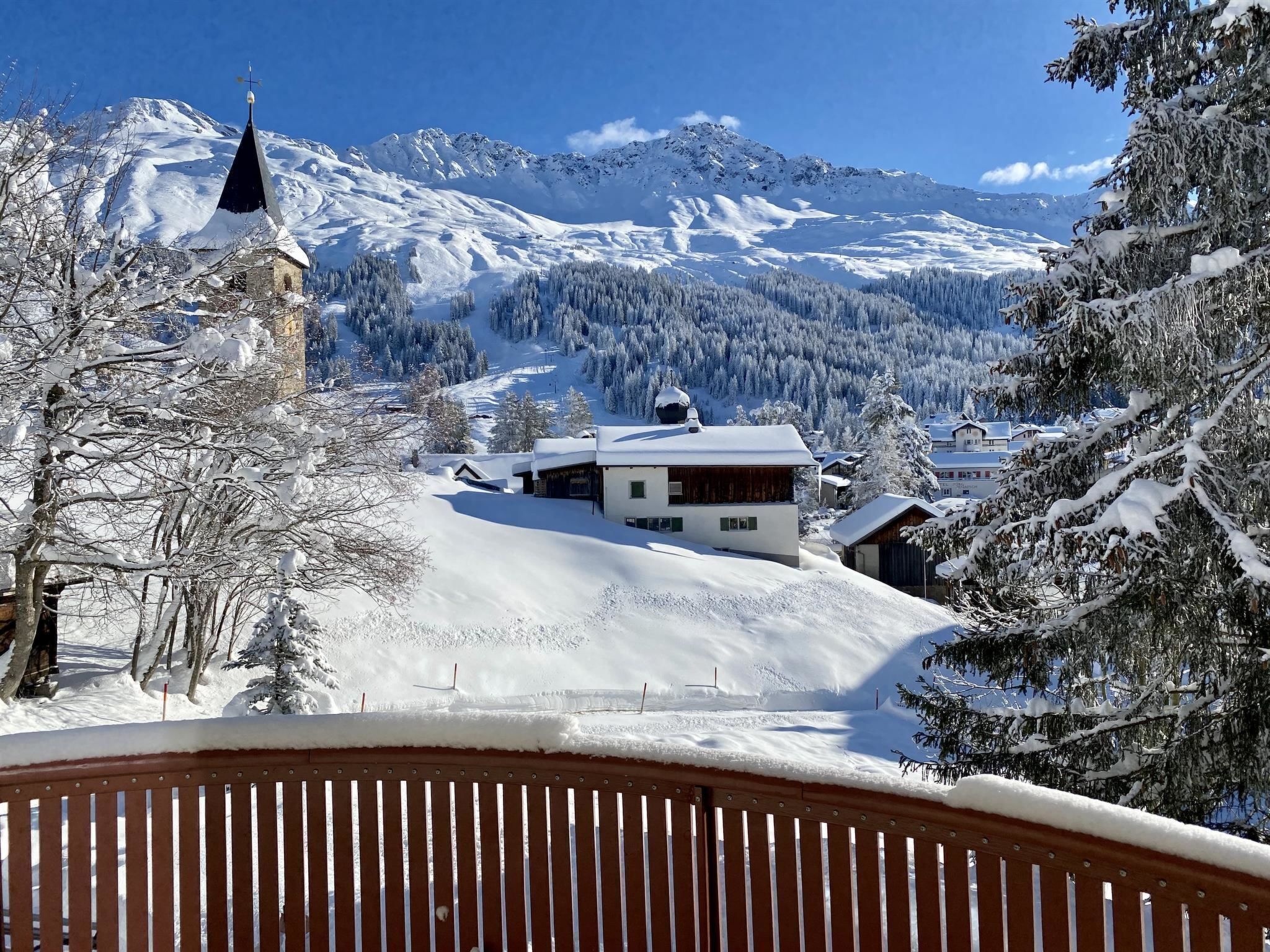 Schneebedeckte Berglandschaft mit einer Kirche und Wohnhäusern.