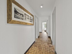 A hallway with a wooden-framed photograph on the wall, a tiled floor, and a door leading to another room. - Bellavista 6 Appartement/Fewo, Bad, WC, 3 Schlafräume Ferienwohnung Bellavista 6 by Interhome (Parpan)