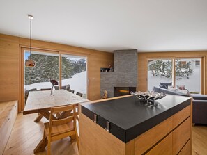 Una cocina moderna con una isla grande, armarios de madera y una chimenea de piedra.