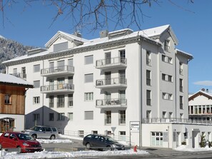 Un edificio de varios pisos con balcones, un estacionamiento y un letrero que indica un hotel.