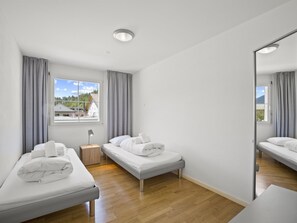 A modern hotel room with two single beds, a bedside table, a lamp, and a large mirror. - Moser Appartement/Fewo Ferienwohnung Moser by Interhome (Churwalden)