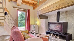A cozy living room with a fireplace, wooden beams, a sofa, and a television. - The swallow's nest - LANGONNET (LANGONNET)