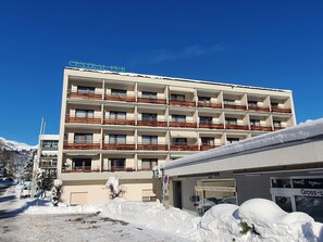 A multi-story hotel with balconies, a sign reading 'CENTRAL PUB,' and a snow-covered ground. - Studio 406 Appartement/Fewo Studio 406 by Interhome (Lenzerheide)